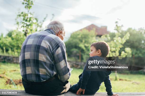 abuelo y nieto al aire libre. - sabiduría fotografías e imágenes de stock