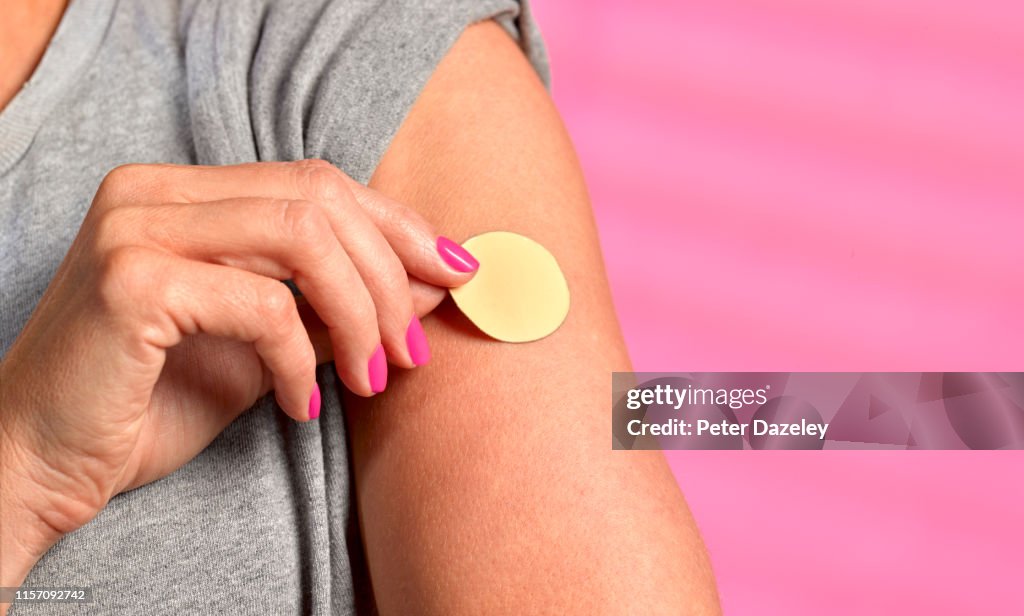 Young woman using nicotine patch to help give up smoking