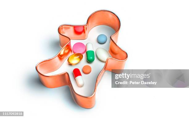 pills sitting inside pastry cutter in the shape of a human body - prozac stock pictures, royalty-free photos & images