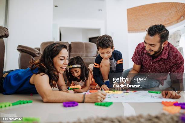 latino family enjoying being together at home and playing with kids. - weekend activities stock pictures, royalty-free photos & images