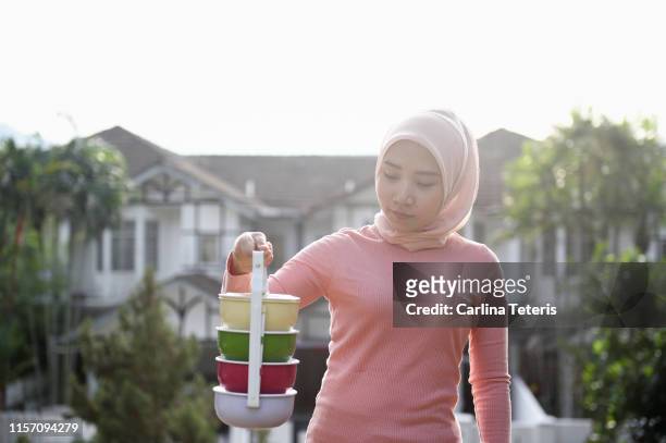 Malay woman carrying a tingkat