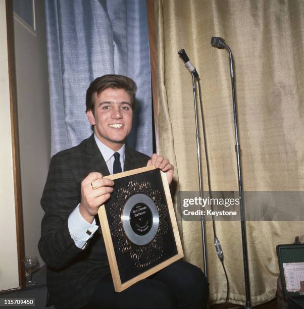 Billy J. Kramer, British singer, poses with the silver disc he received for selling 250,000 copies of his single, 'Little Children', 1964.