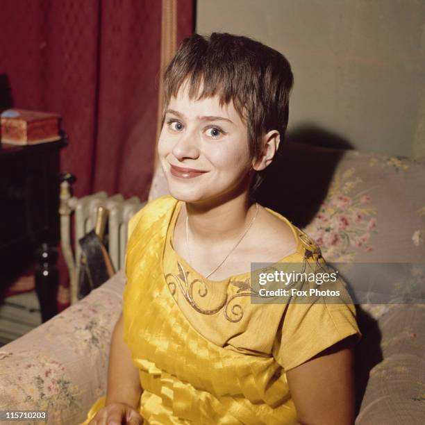 Rita Tushingham, British actress, smiling while posing in a yellow dress, in January 1962.