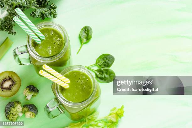 detox diet concept: twee glazen gevuld met groene drank - bleekselderij stockfoto's en -beelden