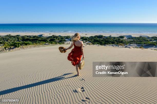 woman on the sand goes to the sea on foot. - antalya stock pictures, royalty-free photos & images