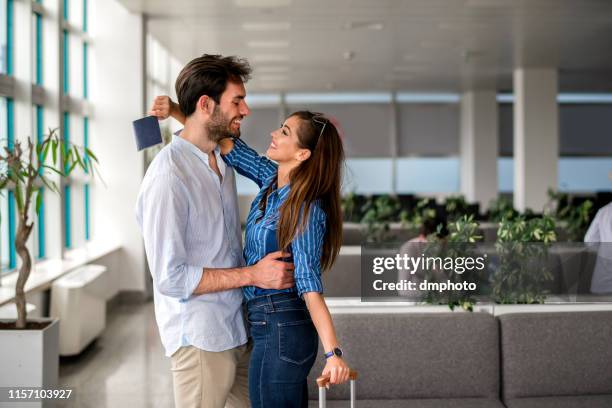 woman embracing man at airport after long separation - introducing girlfriend stock pictures, royalty-free photos & images