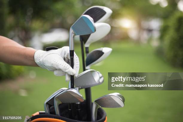 golf clubs drivers over green field background - club de golf photos et images de collection