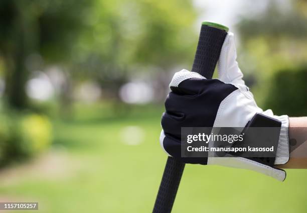 golfer's hands hold golf clubs at the golf course. - golfhandschuh stock-fotos und bilder