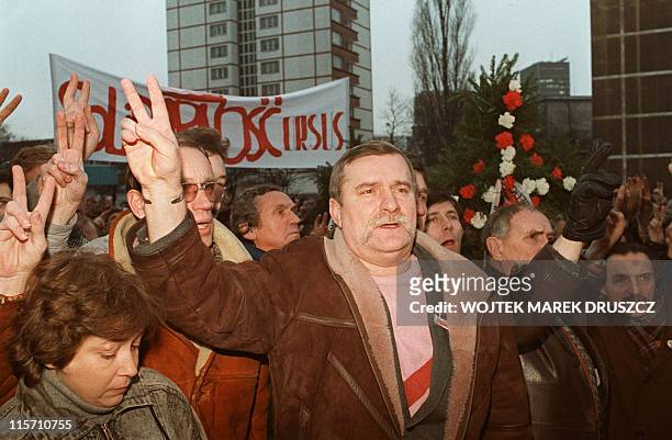 The leader of the banned Polish trade union Solidarity Lech Walesa , flashes a V-sign as he and other shipyard workers demonstrate 13 December 1988...