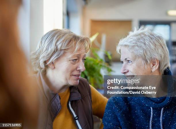 smiling lesbian couple talking in cafe - generation x stock pictures, royalty-free photos & images