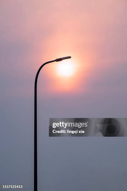 unique perspective of streetlights and sunsets - solar street light stock pictures, royalty-free photos & images