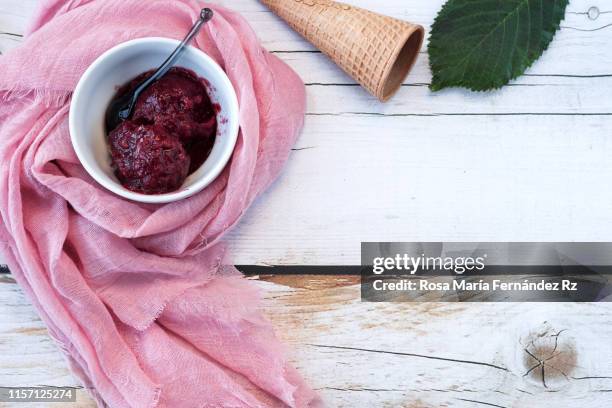 cherry ice cream with cherry leaves, dish towel on a piece of trunk. ingredients above over wooden background table top. directly above and copy space - cherry on top stock-fotos und bilder