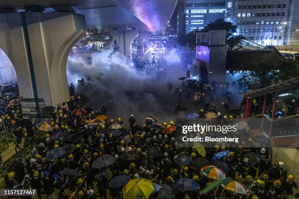 Riot police use tear gas in an attempt to disperse demonstrators during a protest in the Sheung Wan district of Hong Kong, China, on Sunday, July 21,...