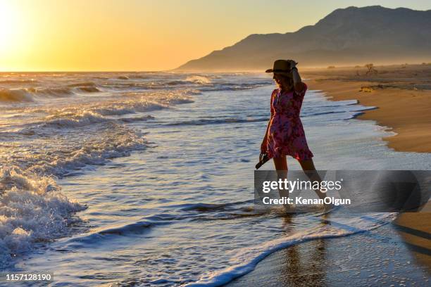 woman walking on the beach at sunset. - caria stock pictures, royalty-free photos & images