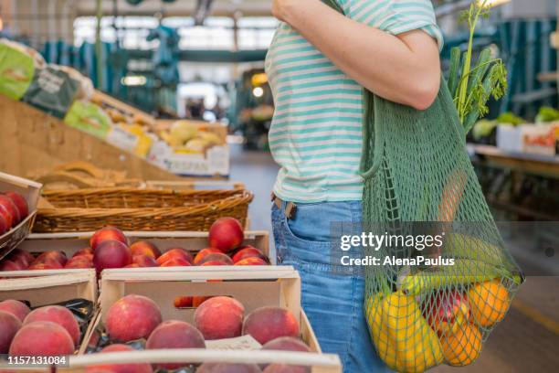 obst und gemüse in einem baumwoll-mesh mehrweg tasche, zero waste shopping konzept - biologie stock-fotos und bilder