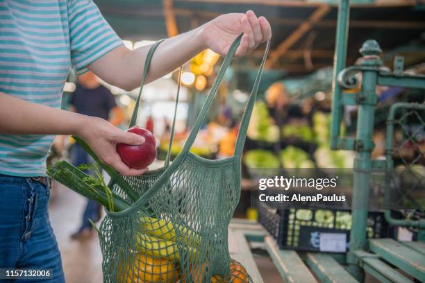 groenten en fruit in een katoenen mesh herbruikbare tas, zero waste shopping op openlucht markt - herbruikbare tas stockfoto's en -beelden