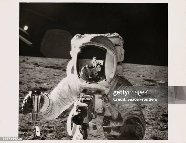 An astronaut on NASA's Apollo 12 lunar landing mission holds a container of lunar soil on the surface of the Moon during the deployment of the Apollo...