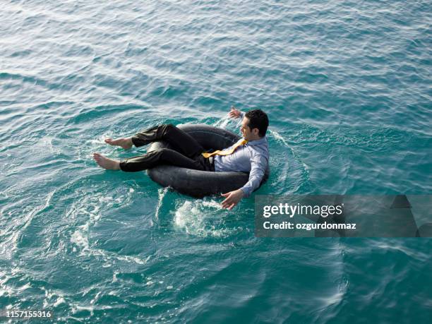 homme d'affaires dans le tube intérieur en mer - bronzage humour photos et images de collection