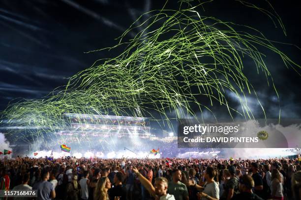 Revelers gather as DJ Tiesto performs at the main stage on the first day of the Tomorrowland music festival on July 19 in Boom. The 15th edition of...