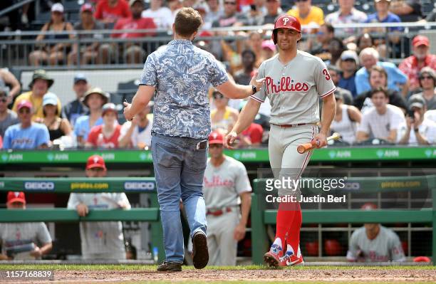 Brad Miller of the Philadelphia Phillies backs away from a fan who came onto the field in the sixth inning during the game against the Pittsburgh...