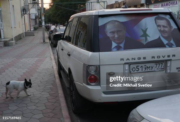 Car with poster of Russian President Vladimir Putin and Syrian President Bashar al-Assad, is seen on the street in disputed territory of Crimea,...