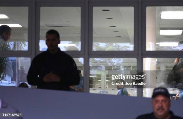 Ricardo Rossello, the governor of Puerto Rico, is seen through a window as he speaks with mayors from his party inside the Yolanda Guerrero Cultural...