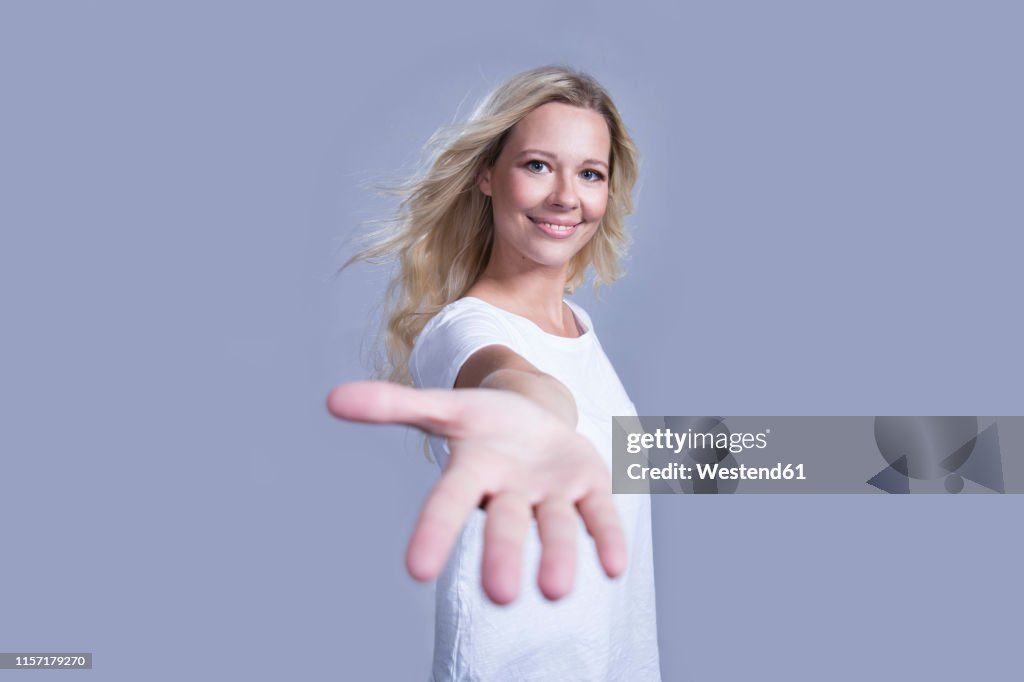 Portrait of smiling blond woman offering helping hand