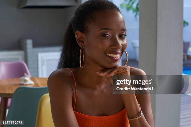 portrait of smiling young woman in a cafe - hoop earring 個照片及圖片檔