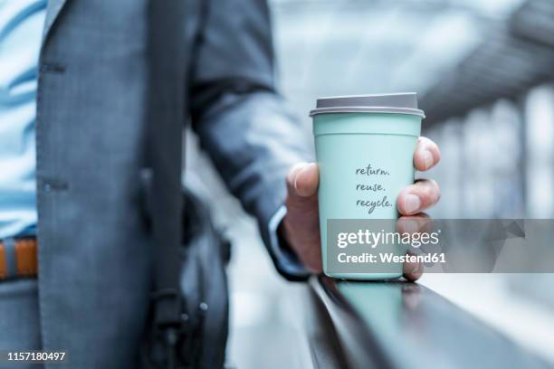 close-up of businessman holding recycable takeaway coffee cup - coffee cup takeaway stock pictures, royalty-free photos & images