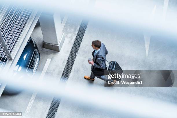 top view of businessman walking with baggage and takeaway coffee at a car park - wheeled luggage 個照片及圖片檔