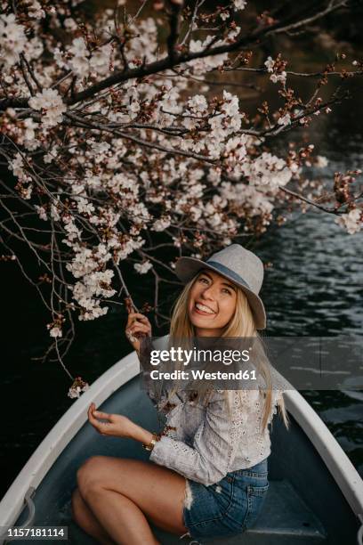 japan, tokio, chidorigafuchi park, smiling woman in rowing boat at cherry tree blossom - blossom tree stockfoto's en -beelden