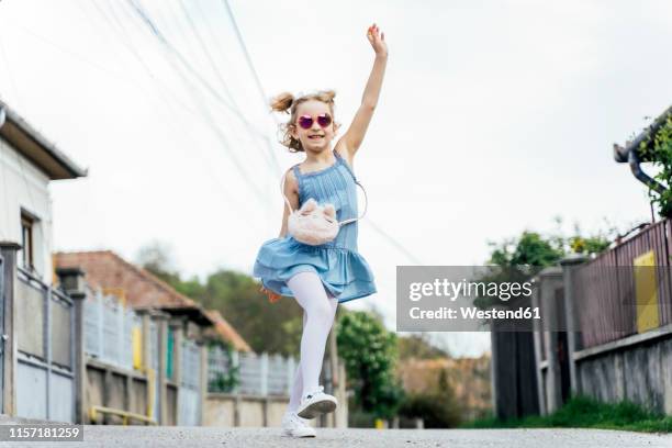 happy little girl dancing on the street - children dancing outside stockfoto's en -beelden