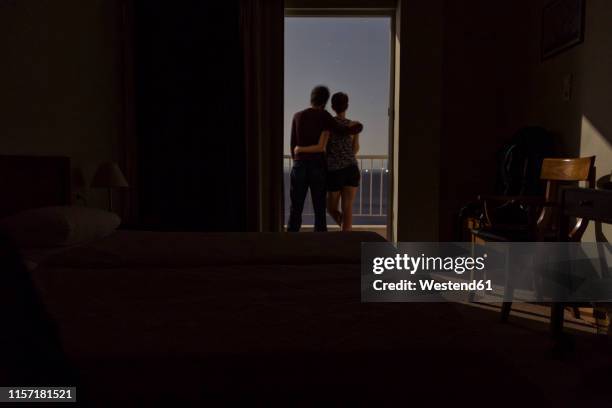 greece, couple standing on balcony at night with view to the sea - moonlight lovers fotografías e imágenes de stock