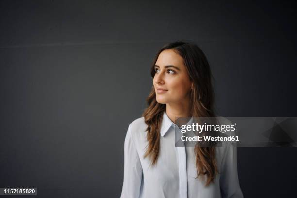 portrait of smiling young businesswoman looking sideways - portrait regard de côté studio photos et images de collection