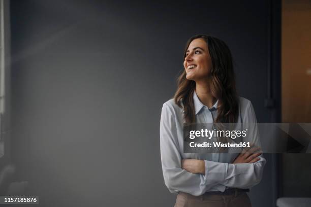 portrait of happy young businesswoman looking sideways - grijze bloes stockfoto's en -beelden