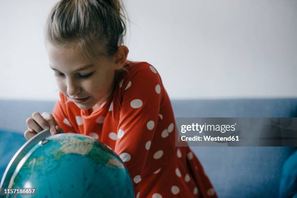 girl at home looking at globe - child globe stockfoto's en -beelden