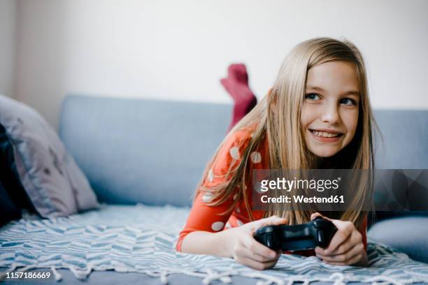 happy girl playing video game at home - red dress child stock pictures, royalty-free photos & images