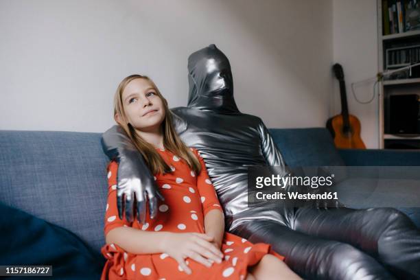 man in morphsuit and girl sitting on couch at home - bodysuit 個照片及圖片檔