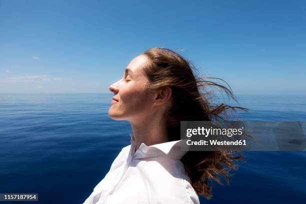 seychelles, indian ocean, profile of woman on ferry enjoying breeze - woman profile stock pictures, royalty-free photos & images