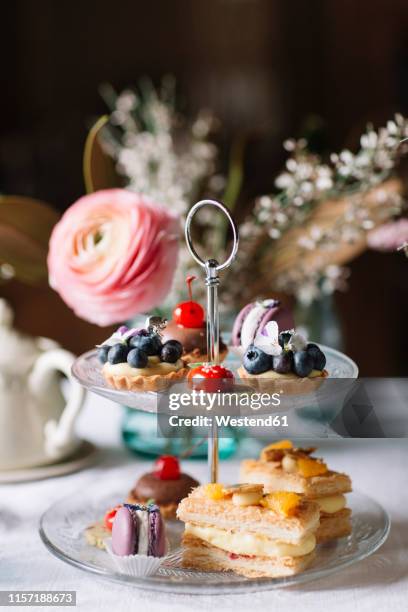 various pastries on glass cake stand - verführung stock-fotos und bilder