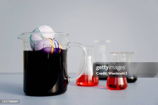 eggs dyed with rubber bands and purple natural colour in measuring flask - gummiband stock-fotos und bilder
