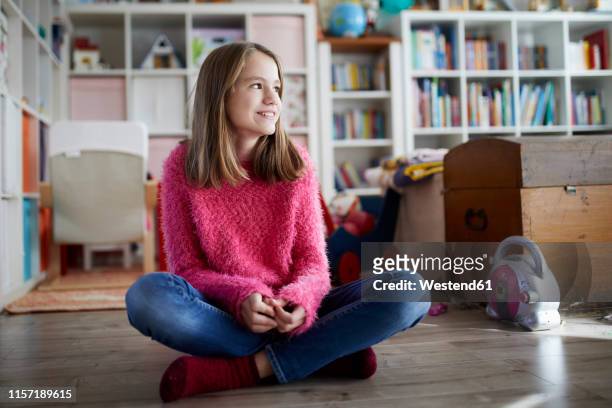 confident girl sitting cross-legged on floor of her room - 12 13 jahre mädchen stock-fotos und bilder