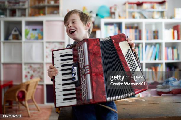 boy exercising on his accordeon - acordeonista fotografías e imágenes de stock