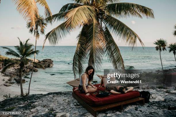 mexico, quintana roo, tulum, two happy young women relaxing on the beach - tulum ストックフォトと画像