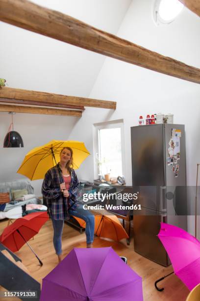 young woman with umbrellas at home - leaky roof stock pictures, royalty-free photos & images