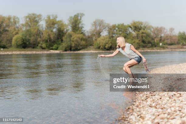 happy mature woman splashing in a river - ankle deep in water bildbanksfoton och bilder