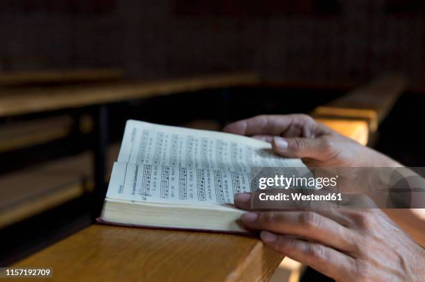 hands on hymnbook on pew - libro de himnos fotografías e imágenes de stock