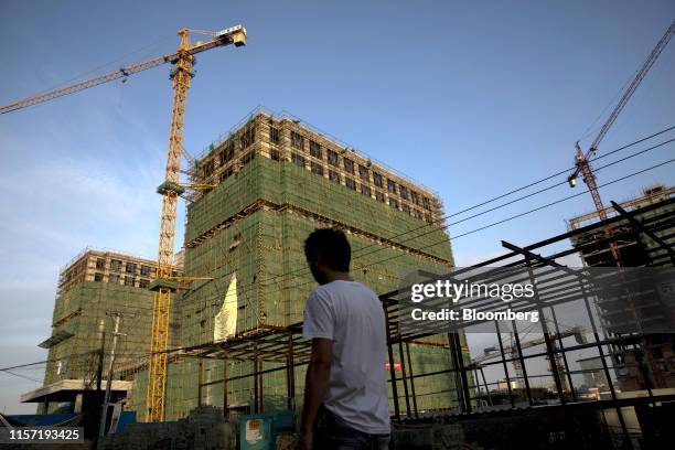 Pedestrian walks past a construction site in Sihanoukville, Cambodia, on July 7, 2019. In Sihanoukville, a once-sleepy resort town, Cambodians are...