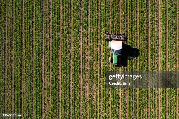 tractor cultivating field, view from above - plowed field stock pictures, royalty-free photos & images