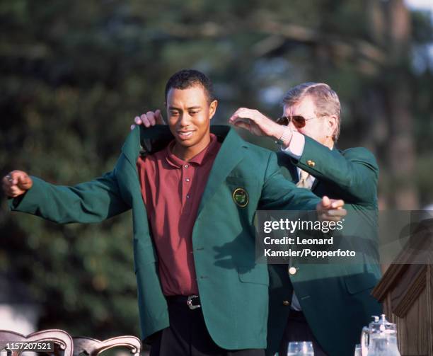 Tiger Woods of the USA is presented with his Green Jacket by the Tournament chairman Hootie Johnson after Woods' 3rd victory in the US Masters Golf...